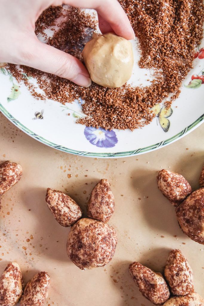 Rolling snickerdoodles in cinnamon sugar